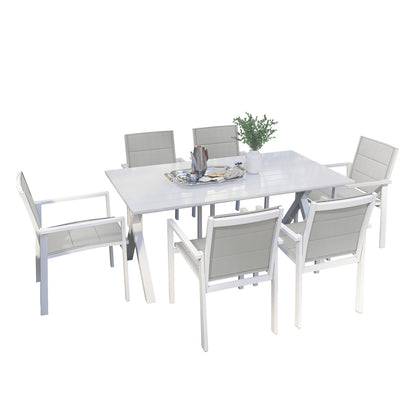 Jensen 6 Seater Aluminum Outdoor Dining Set in Light Grey, featuring a sleek table with X-style legs, six matching chairs, and a centerpiece vase with green foliage on a neatly set table.