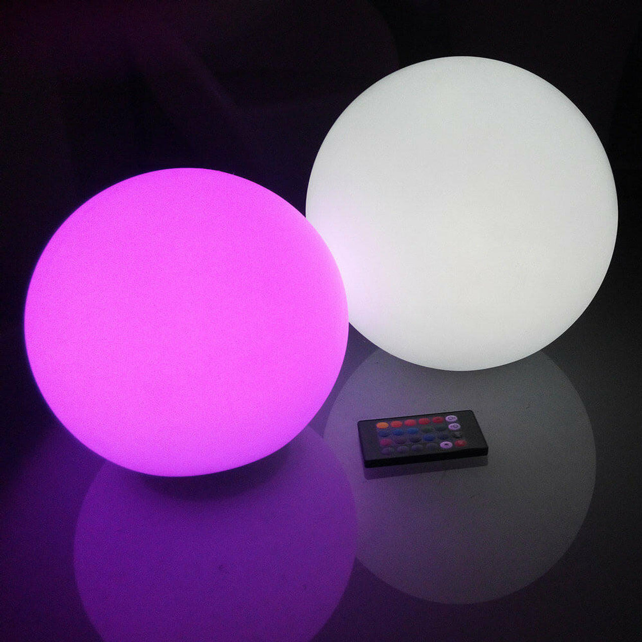 Close-up of Waterproof Outdoor LED Ball Lights Décor 20cm, featuring two glowing balls beside a remote control, highlighting the sleek design and functionality for enhancing outdoor spaces.