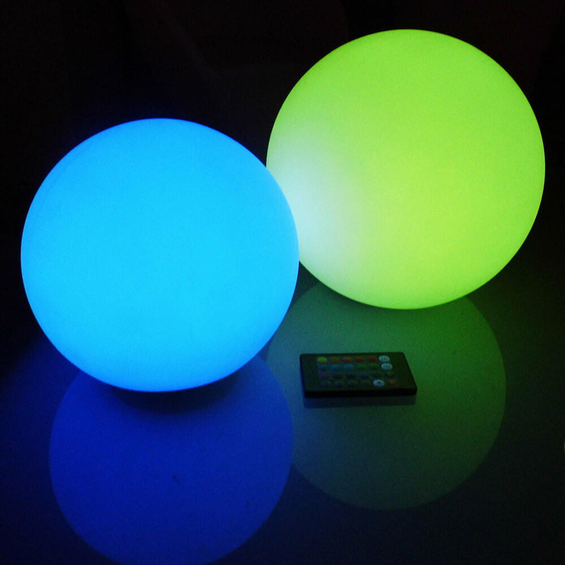 Waterproof Outdoor LED Ball Lights Décor 20cm on a table with a remote control and glowing balls, showcasing its floating water feature and versatile use for enhancing outdoor spaces.