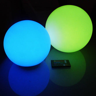 Waterproof Outdoor LED Ball Lights Décor 20cm on a table with a remote control and glowing balls, showcasing its floating water feature and versatile use for enhancing outdoor spaces.