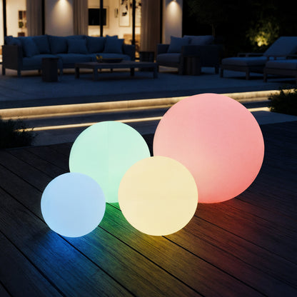 Sphero 20cm Floating Waterproof Outdoor LED Ball Lights glow in pastel hues on a patio deck, enhancing a modern lounge area with their enchanting, floating design.