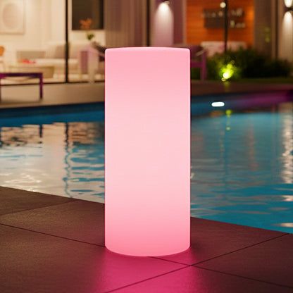 The image features the 16 Colour Outdoor LED Bollard Light in Multicolour, glowing warmly beside a pool on a tiled deck, with its pink hue reflecting in the water, enhancing the serene ambiance.