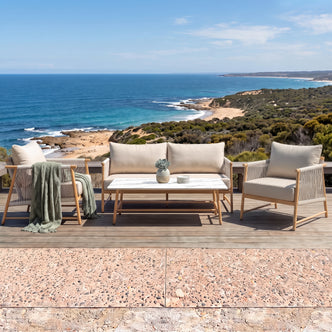 Outdoor furniture set on a deck overlooking the ocean