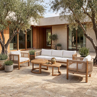 Outdoor furniture set arranged on a patio with plants and a modern house in the background