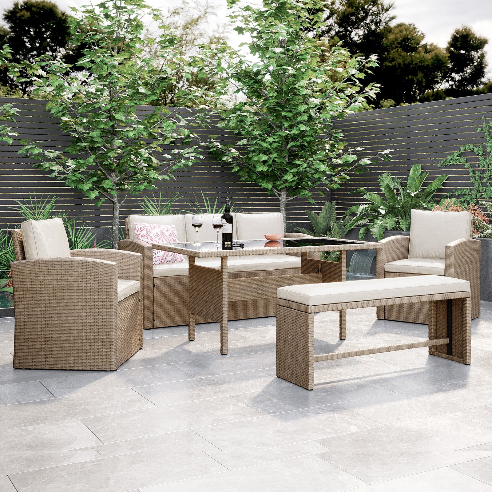 Close-up view of the Mapa 7 Seater Wicker Outdoor Sofa Dining Set showcasing its wicker texture and design, highlighting two wine glasses on a table amidst lush outdoor scenery.