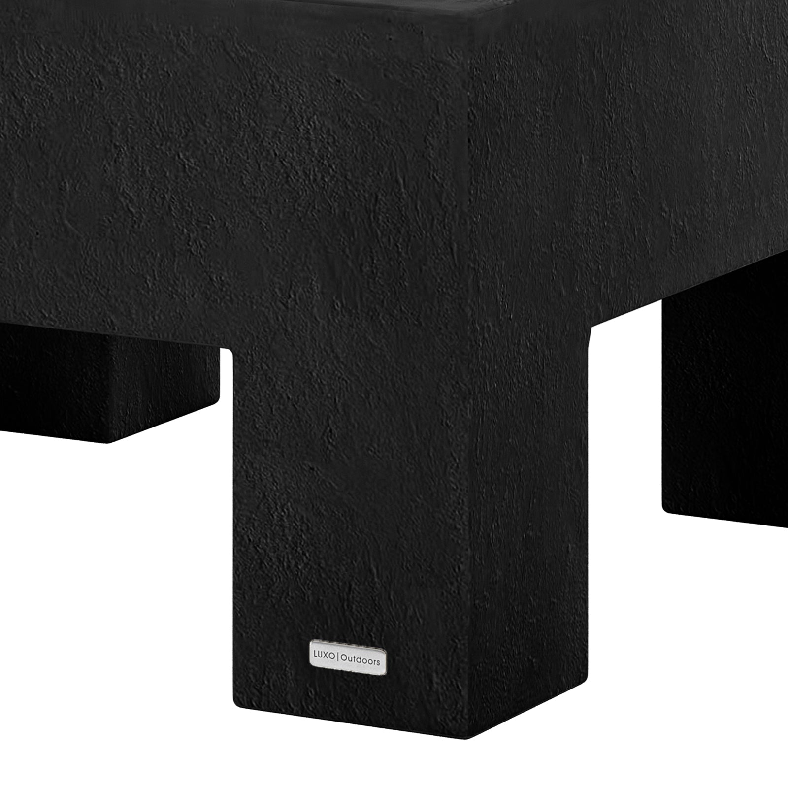 Detail shot of the Maxon White concrete coffee table's surface and leg, featuring the Luxo Outdoors tag