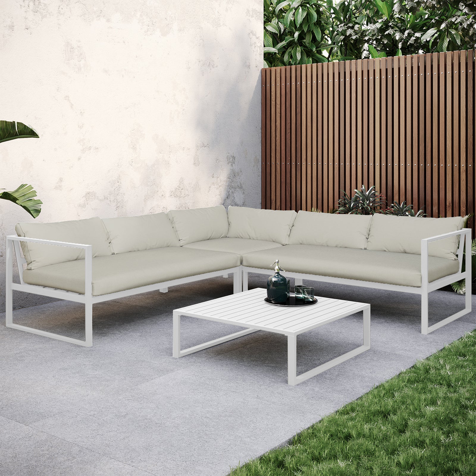Moana 6 Seater Aluminium Outdoor Corner Sofa Lounge Set Sandy Beige; sleek design with cushioned seating, white aluminum frame. Shown on a patio with a coffee table, enhancing outdoor comfort and style.
