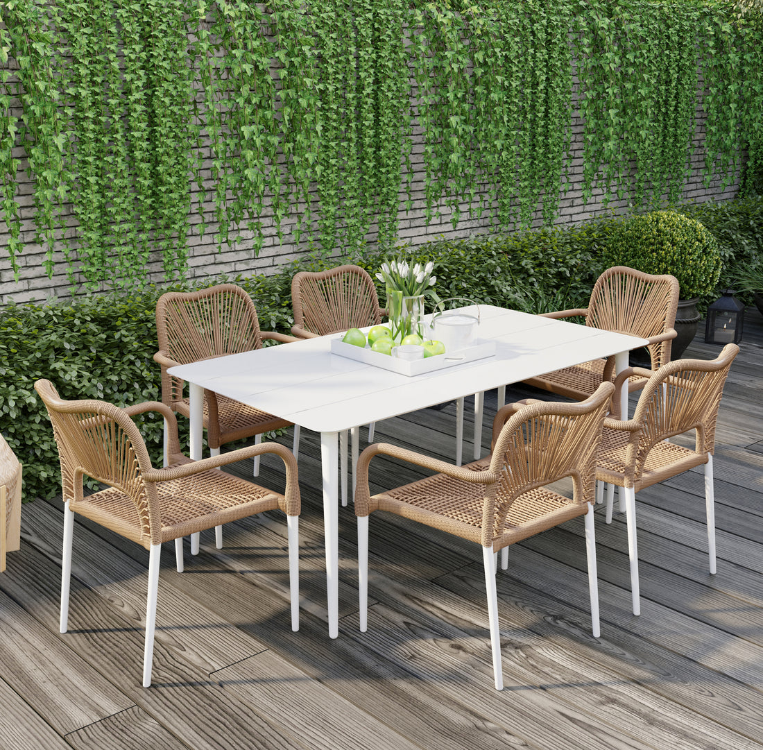 Navarre 6 Seater Aluminium Outdoor Dining Set in Natural features a modern white table with six woven rattan-style chairs, creating a stylish garden ambiance with a serving tray of green apples and white tulips.