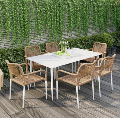 Navarre 6 Seater Aluminium Outdoor Dining Set in Natural features a modern white table with six woven rattan-style chairs, creating a stylish garden ambiance with a serving tray of green apples and white tulips.