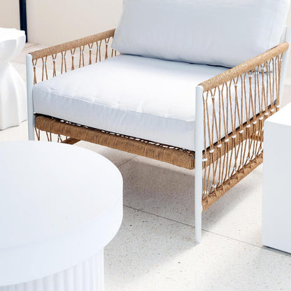 Nuevo 4 Seater Wicker Outdoor Lounge Set in Light Beige, featuring a modern white metal frame, thick white cushions, and natural-colored rope detailing, situated in a bright, minimalist space with a round table edge.