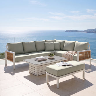 Outdoor sectional sofa set with ottoman and coffee table on a patio overlooking the ocean