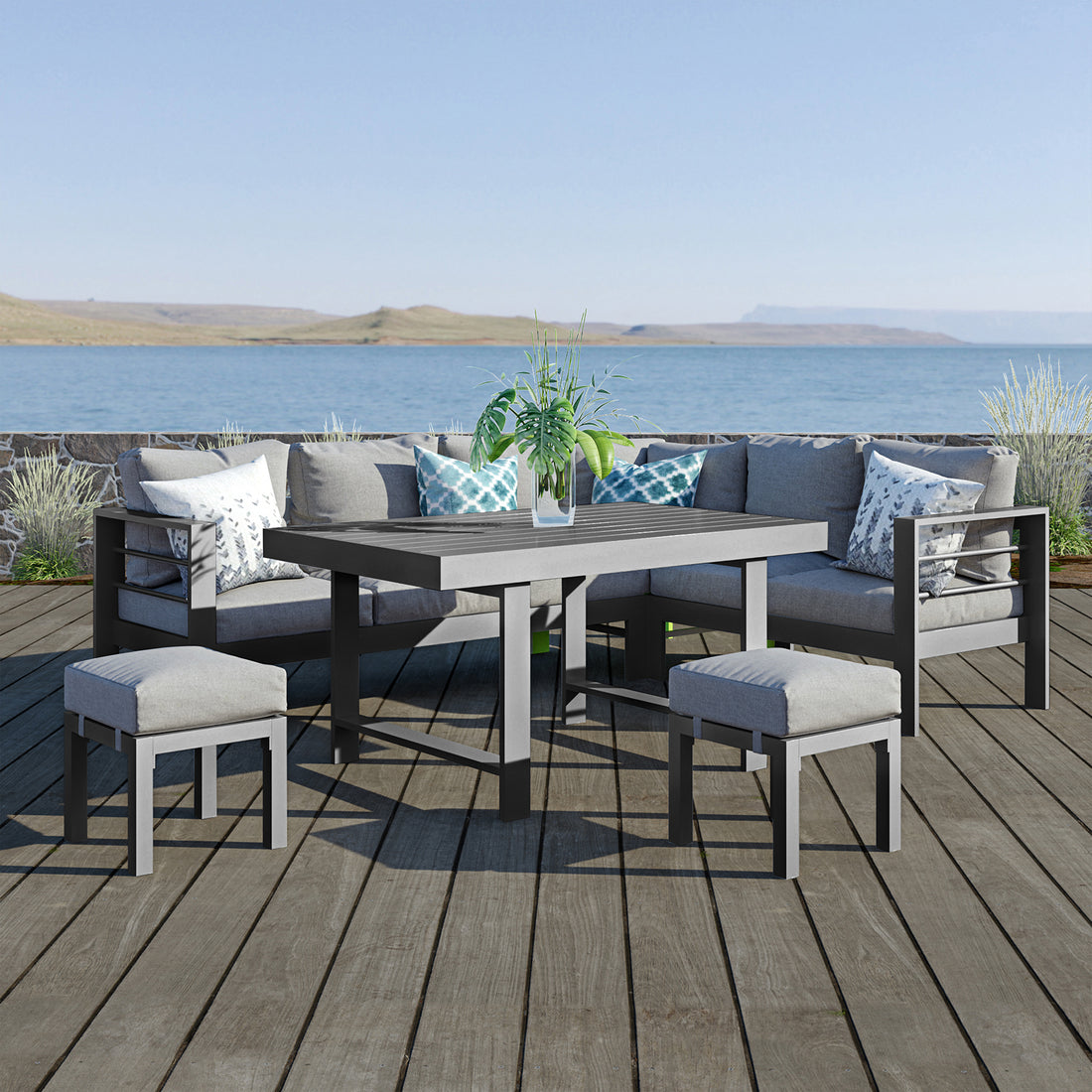 Portland Outdoor Corner Sofa Lounge with Footstools Grey, featuring plush cushions on a robust aluminum frame, paired with a sleek coffee table, set in a serene outdoor setting.