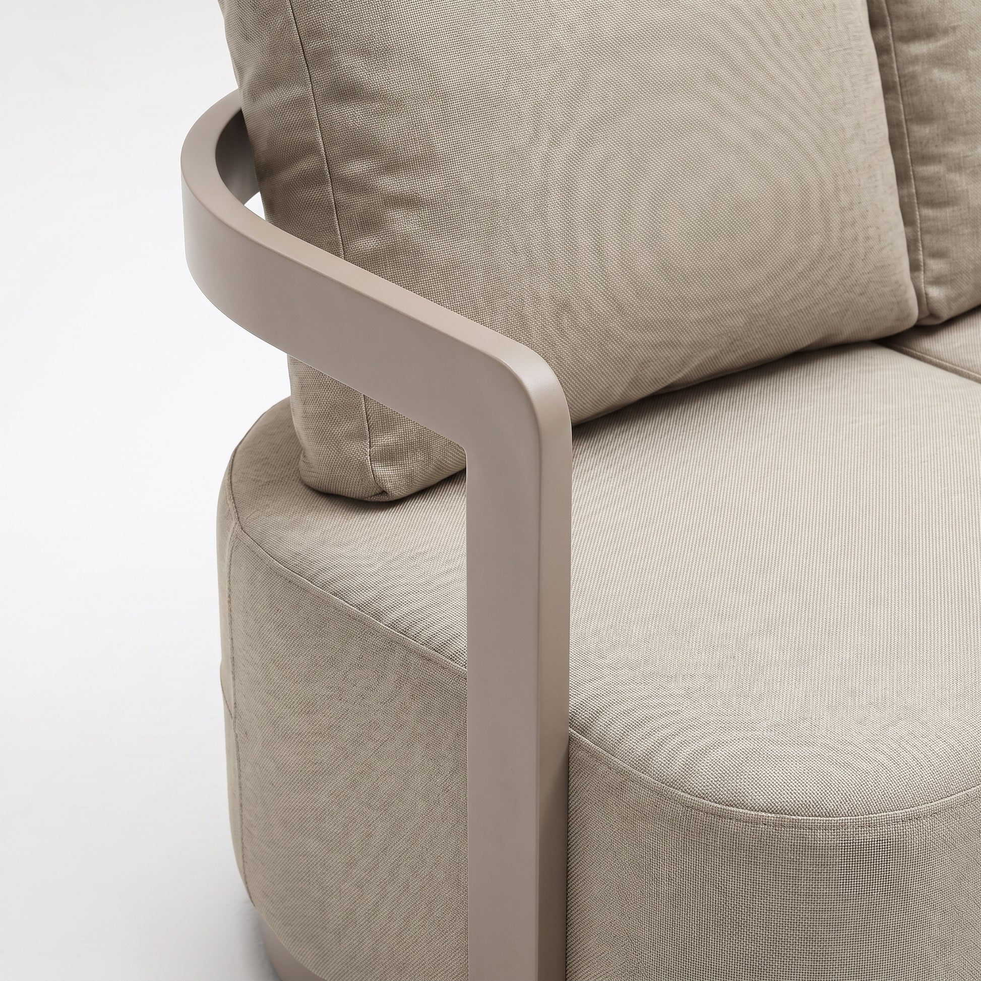 Close-up of a beige upholstered armchair corner and armrest on white background