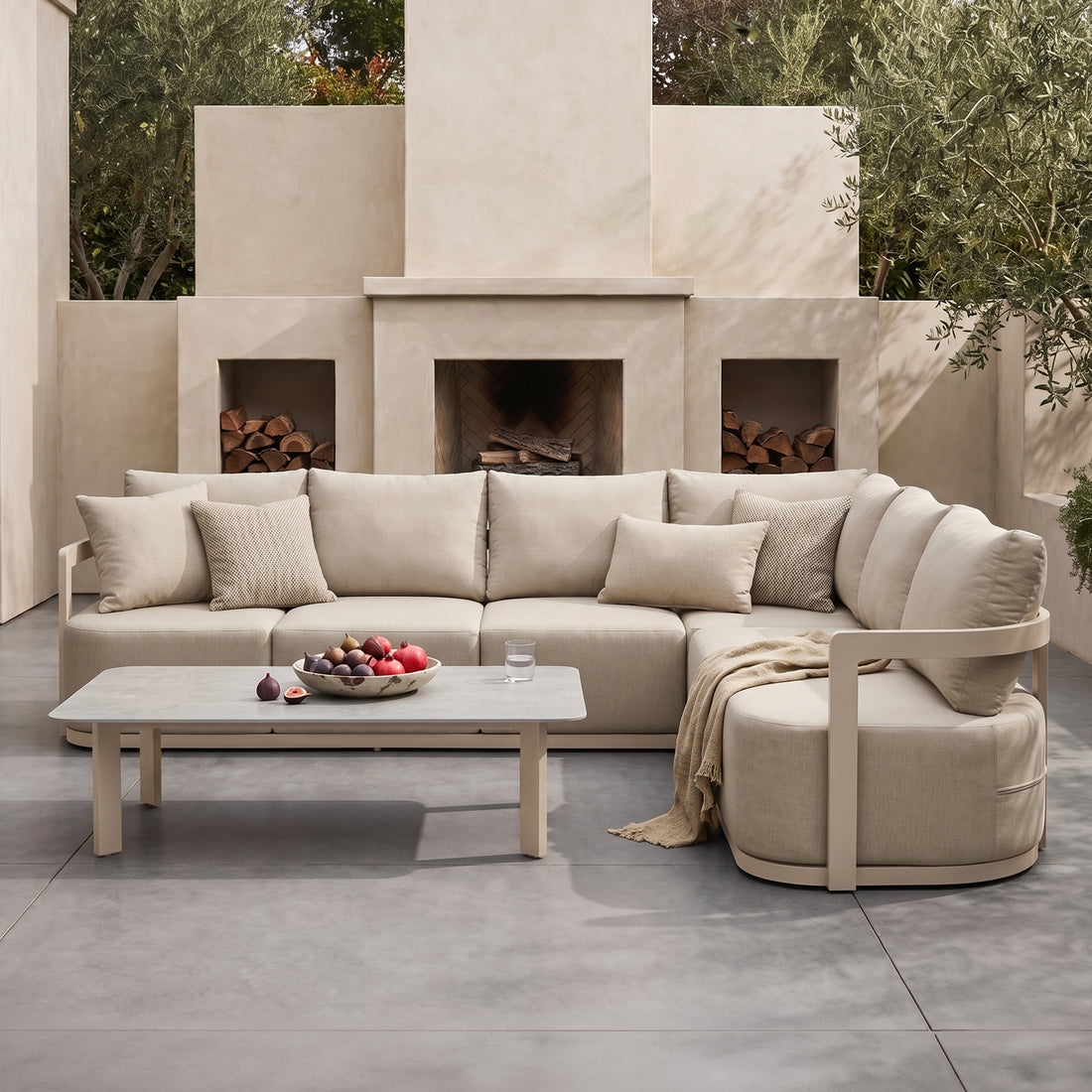 Outdoor beige sectional sofa set with coffee table styled on a patio in a real-life setting