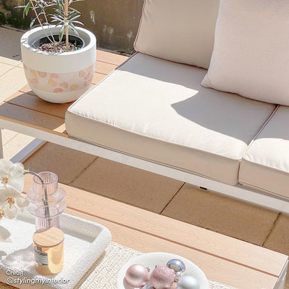 Rosa 5 Seater Outdoor Corner Sofa Lounge with Coffee Table shown in an outdoor setting, surrounded by a plant in a pot and ornaments on a table, highlighting its stylish design and comfortable seating.