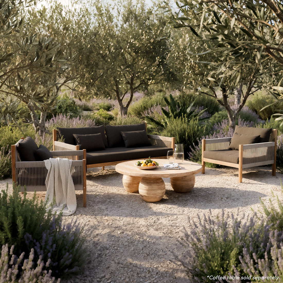 Savin 4 Seater Hardwood Outdoor Sofa Set in Light Grey on a stone terrace, featuring charcoal-cushioned sofa and armchairs with rope detailing, complemented by a wooden coffee table and coastal view.
