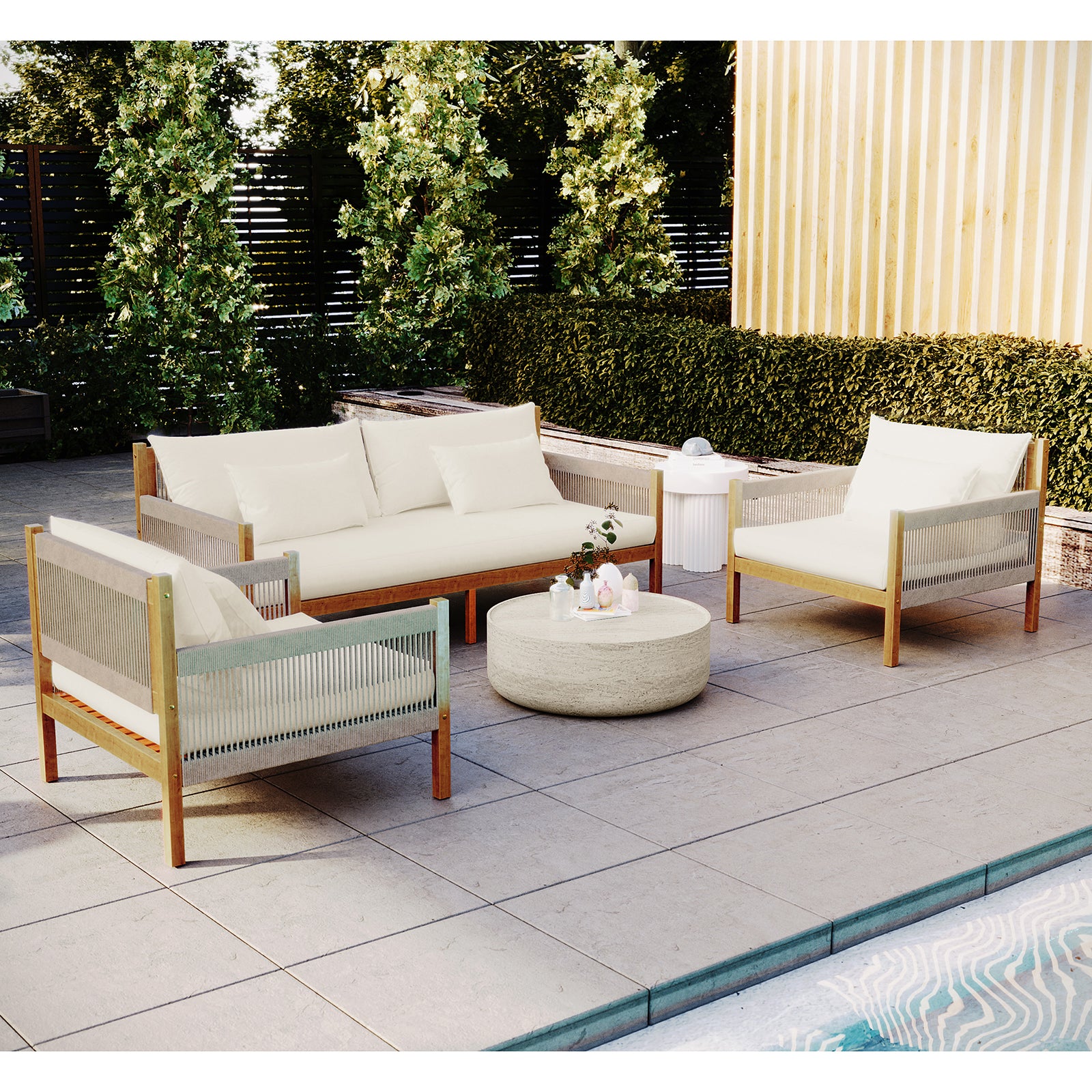 Savin & Myrtle Outdoor Sofa Set with Coffee Table in Beige features a two-seater sofa, two armchairs with woven sides, and a stone coffee table, all set by a pool.