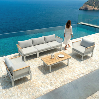 Sierra 5-Seater Outdoor Lounge Set in Grey by an infinity pool, featuring a three-seat sofa, two armchairs, and a coffee table with a ceramic pitcher and glass, exuding a resort-like ambiance.