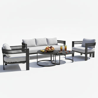 Sorrelle 5-Seater Curved Outdoor Sofa Set in Black features a three-seat sofa, two armchairs with light gray cushions, and two nested coffee tables with fruit and iced tea displayed.