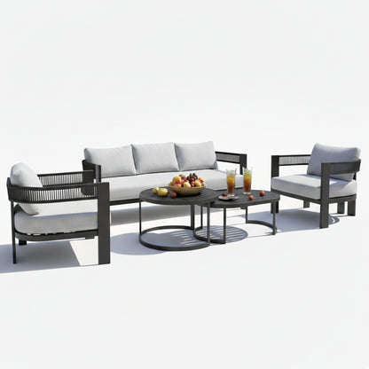 Sorrelle 5-Seater Curved Outdoor Sofa Set in Black features a three-seat sofa, two armchairs with light gray cushions, and two nested coffee tables with fruit and iced tea displayed.