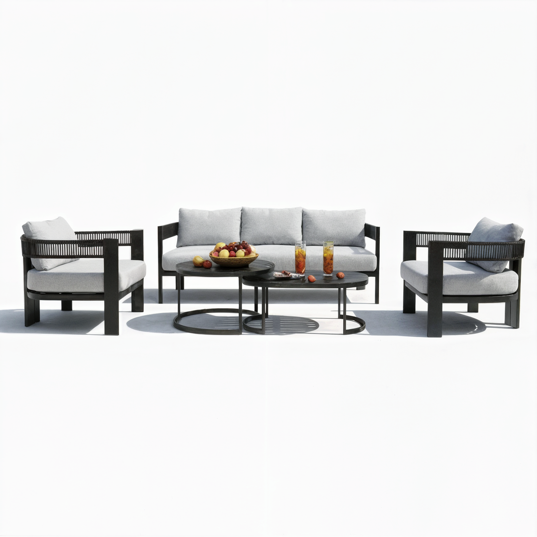 Sorrelle 5-Seater Curved Outdoor Sofa Set in Black, featuring light gray cushioned armchairs, a matching sofa, and two nesting coffee tables with fruit and drinks, arranged for a stylish patio setting.