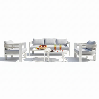 Sorrelle 5-Seater Curved Outdoor Sofa Set in Light Grey features a three-seat sofa, two armchairs with gray cushions, and two white metal nesting tables with fruit and drinks displayed.