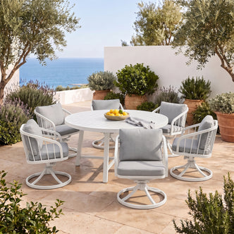 Outdoor dining set arranged on a sunny patio with plants and ocean view