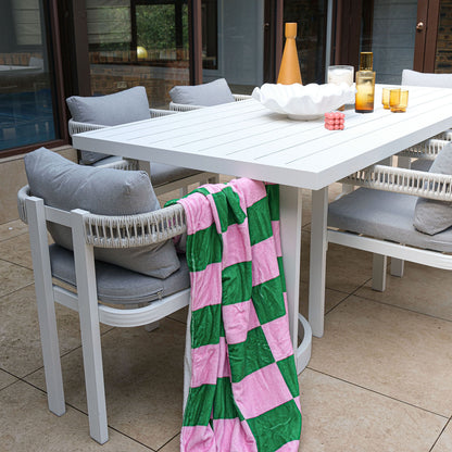Tavari 6-Seater Aluminium Outdoor Dining Set in Light Grey features a rectangular table, woven-rope chairs with cushions, and decorative items on a tiled patio, ideal for outdoor gatherings.