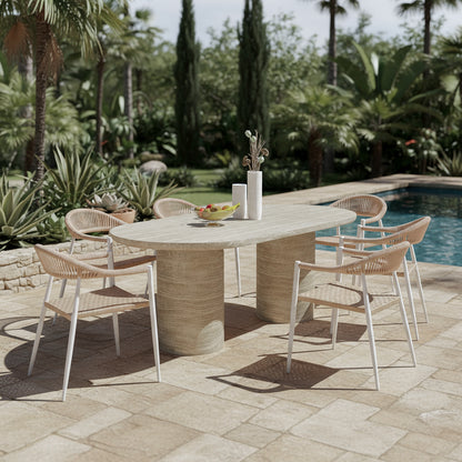 Tierre & Nemma 6 Seater Outdoor Concrete Dining Set in Beige features an oval stone table with pedestal bases, six woven chairs, and two vases with dried botanicals on the table.
