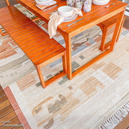 Trinity 8 Seater Hardwood Outdoor Dining Bench Set in Natural featuring an orange-stained table, matching benches on an earth-tone rug with dinnerware and candle holders, ideal for outdoor gatherings.