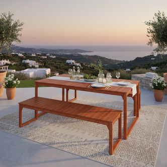 The Trinity 8 Seater Hardwood Outdoor Dining Bench Set in Natural is displayed on a stone-tiled terrace with a wooden table, matching bench, styled for al fresco dining against a scenic sunset backdrop.