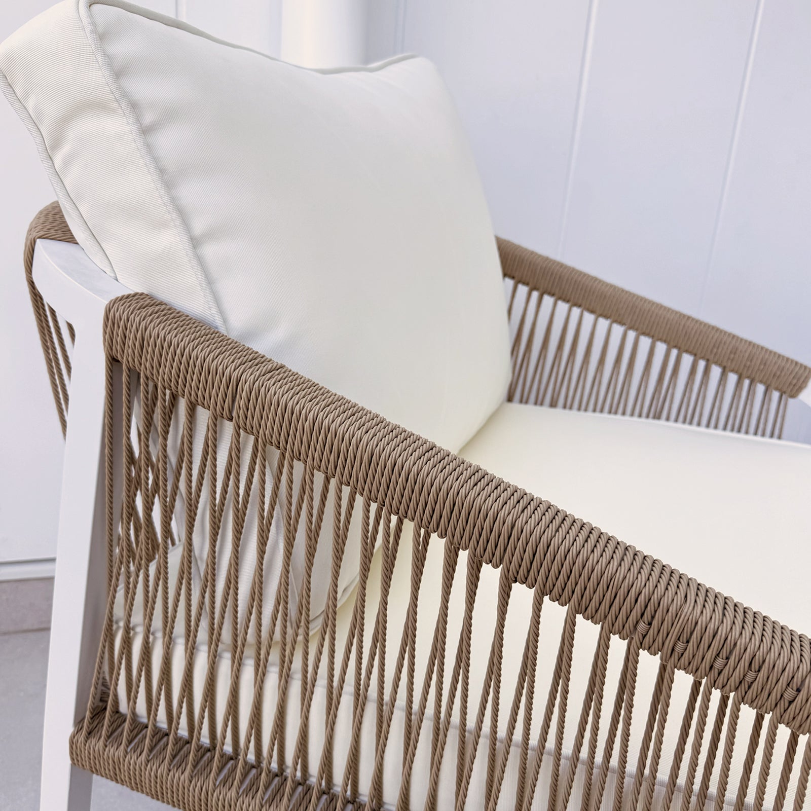 Close-up of the Vernon 5 Seater Aluminium Outdoor Sofa Set in Cream White, featuring a modern lounge chair with a white cushion, white frame, and tan-brown rope-wrapped armrests.