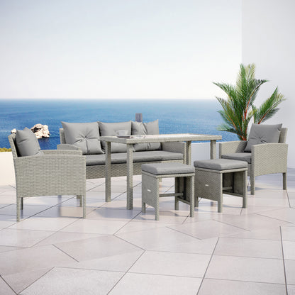 Vero 7 Seater Wicker Outdoor Sofa Dining Set Warm Grey, featuring a coffee table on tile, surrounded by a three-seater sofa, two chairs, and footstools, ideal for outdoor relaxation.
