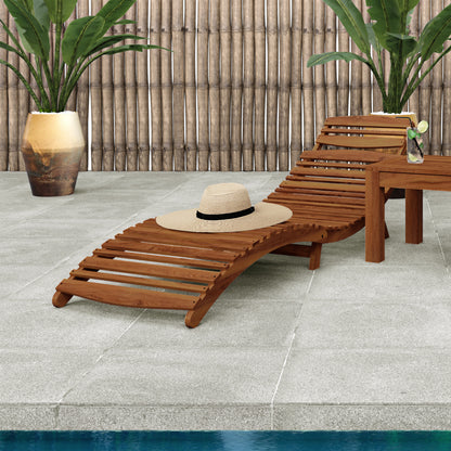 Wave Timber Outdoor Foldable Sun Lounge Natural featuring an ergonomic wave design, sustainable eucalyptus wood frame, and a hat placed on the lounge. Ideal for relaxing outdoors.