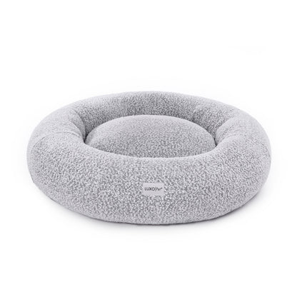 Kyra Large Boucle Pet Bed – White with Black Base, featuring a curved bolster design for neck support, soft boucle fabric, and a modern aesthetic suitable for large dogs.