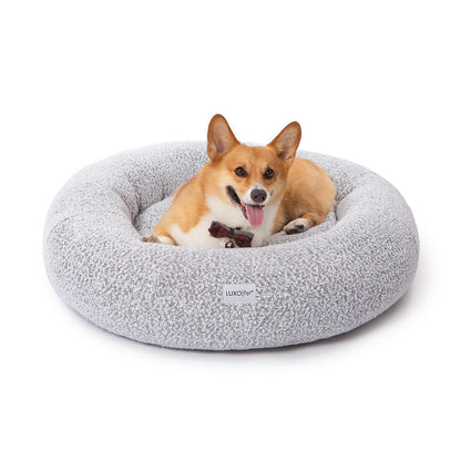 Welsh Corgi resting comfortably in the Kyra Large Boucle Pet Bed, showcasing its soft, supportive curved bolsters and stylish design with a white finish and contrasting black non-slip base.