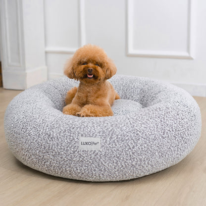 Kyra Medium Boucle Pet Bed – White with Black Base, features raised bolsters and plush, scratch-resistant boucle fabric. Designed for comfort and stability with a non-slip base, ideal for modern homes.
