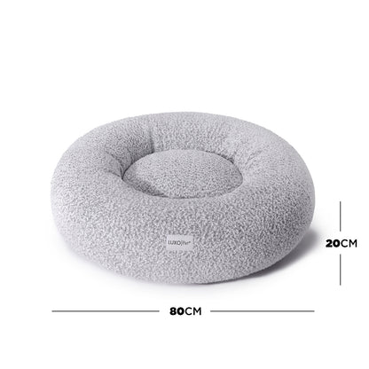 Kyra Medium Boucle Pet Bed – White with Black Base, featuring raised bolster edges for support, plush boucle fabric, and a non-slip base, providing a stylish and comfortable resting spot for pets.