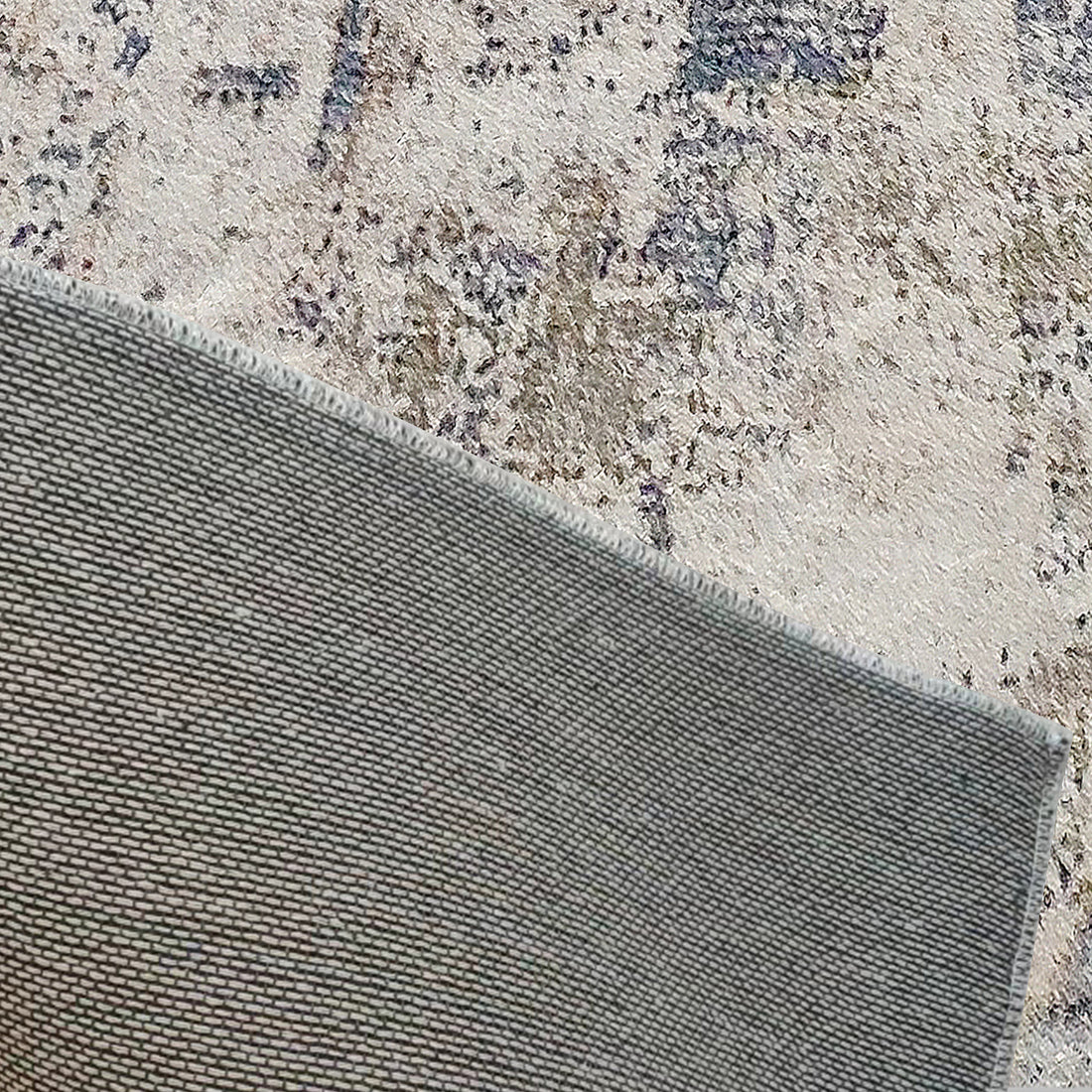 Ari 160x230cm Medium Tufted Printed Indoor Floor Rug with a light-coloured, distressed abstract design, and a visible textured underside, ideal for modern decor and high-traffic areas.