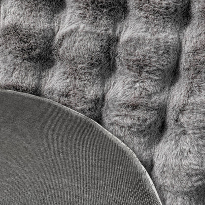 Close-up of the Armida 160cm Round Fluffy Faux Fur Bubble Rug in Grey, showcasing its tufted, shaggy texture with a corner flipped, revealing the plain fabric backing.