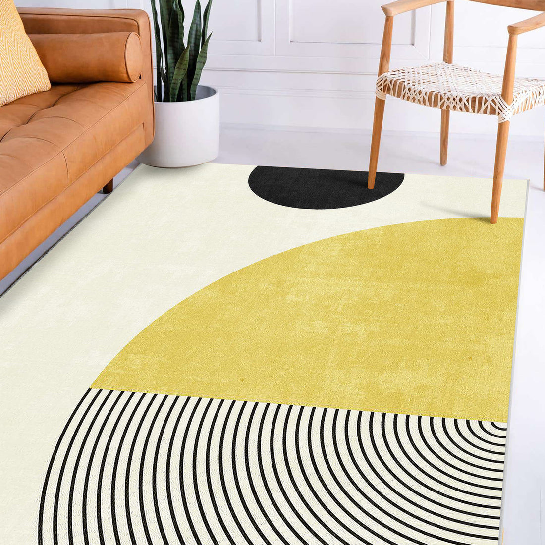 Axland Modern Abstract Rug 120x180cm features a bold geometric pattern with semicircles and arcs, perfectly complementing the minimalist space with a caramel-tan sofa and light wood chair.