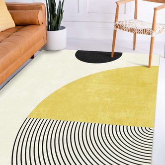 Axland Modern Abstract Rug 160x230cm featuring a cream background with mustard-yellow and black semicircles, concentric arcs, complementing a camel-tan leather sofa and white woven seat chair in a minimalist living space.