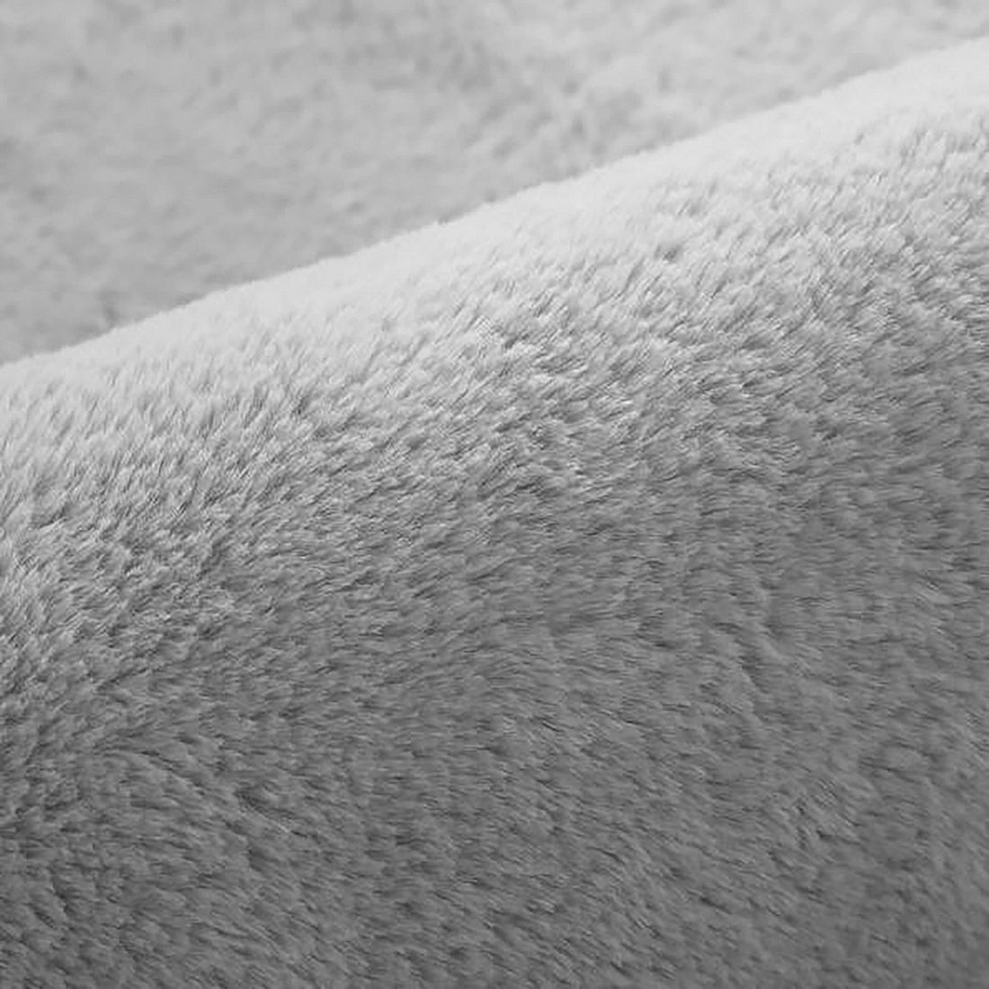 Azaliya 200x300cm Faux Rabbit Fur Floor Rug in Silver, showcasing a close-up of its soft, dense, short pile fibers with a gentle fold, highlighting its luxurious, cosy texture.