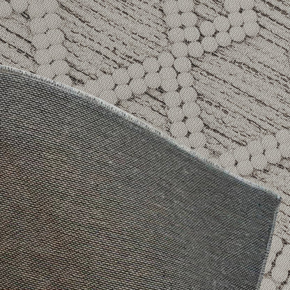 Close-up of the Benita 200x300cm Large Soft Modern Printed Indoor Floor Rug, featuring a folded darker gray-green woven fabric over a lighter gray/beige textile with an abstract linear pattern.