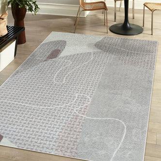 Elena Modern Abstract Tufted Rug 120x180cm on light wood floor, beneath a black pedestal table, two rattan chairs, a bench with cushion, and a planter with leafy plant.