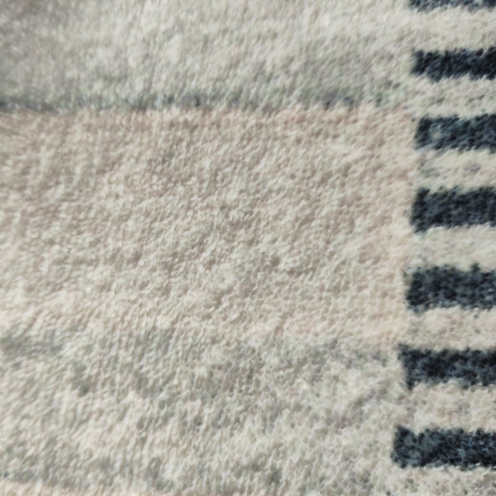Close-up of Elimas 200x300cm Soft Contemporary Printed Floor Rug, showcasing its plush terrycloth surface with a subtle pattern and darker striped edge, highlighting its inviting texture and modern design.
