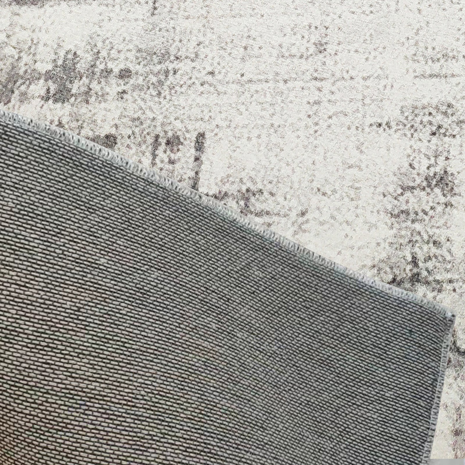 Franco 120x180cm Small Tufted Contemporary Indoor Rug, shown flipped to reveal its non-slip rubber-backed grid, lying on a light-patterned floor, showcasing its durable construction and practical design.