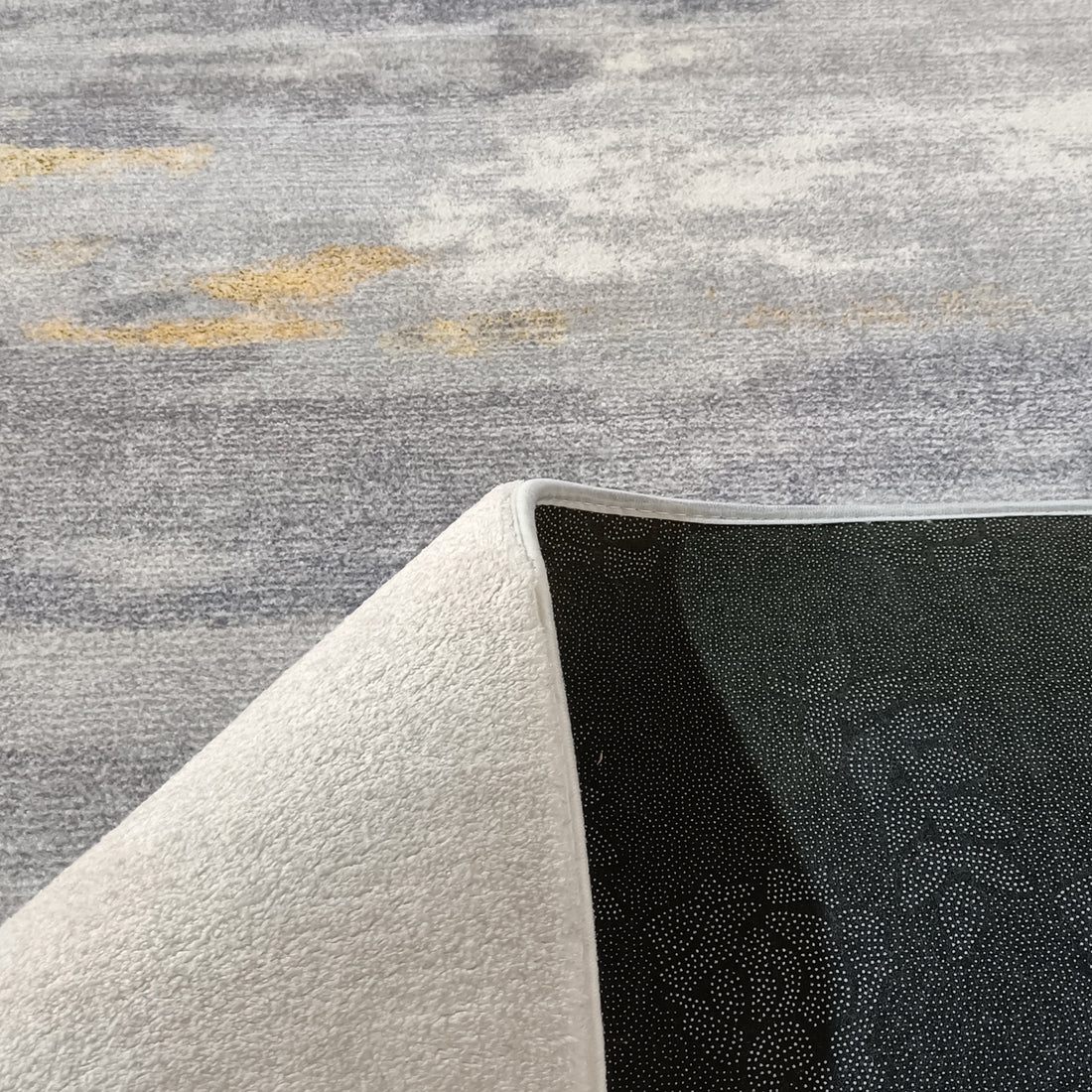 Getbo 160x230cm Medium Modern Indoor Floor Rug displayed with one corner flipped, showcasing its black, dotted non-slip backing and soft, white terry-style fabric top for a cosy, luxurious feel.