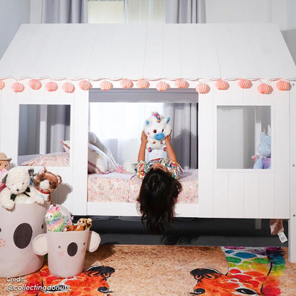Child's playhouse bed scene with Giraffe 160x230cm Medium Kids Printed Indoor Rug, featuring two colorful giraffes, visible beneath toy bins and plush toys, complementing the playful, cozy bedroom setting.