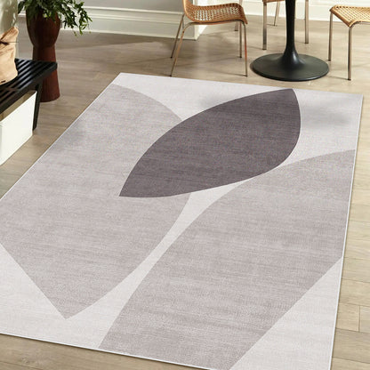 Glote 120x180cm Small Abstract Indoor Floor Rug with a gray and taupe leaf motif on a light wood floor, accompanied by a round table, rattan chairs, and a potted plant.